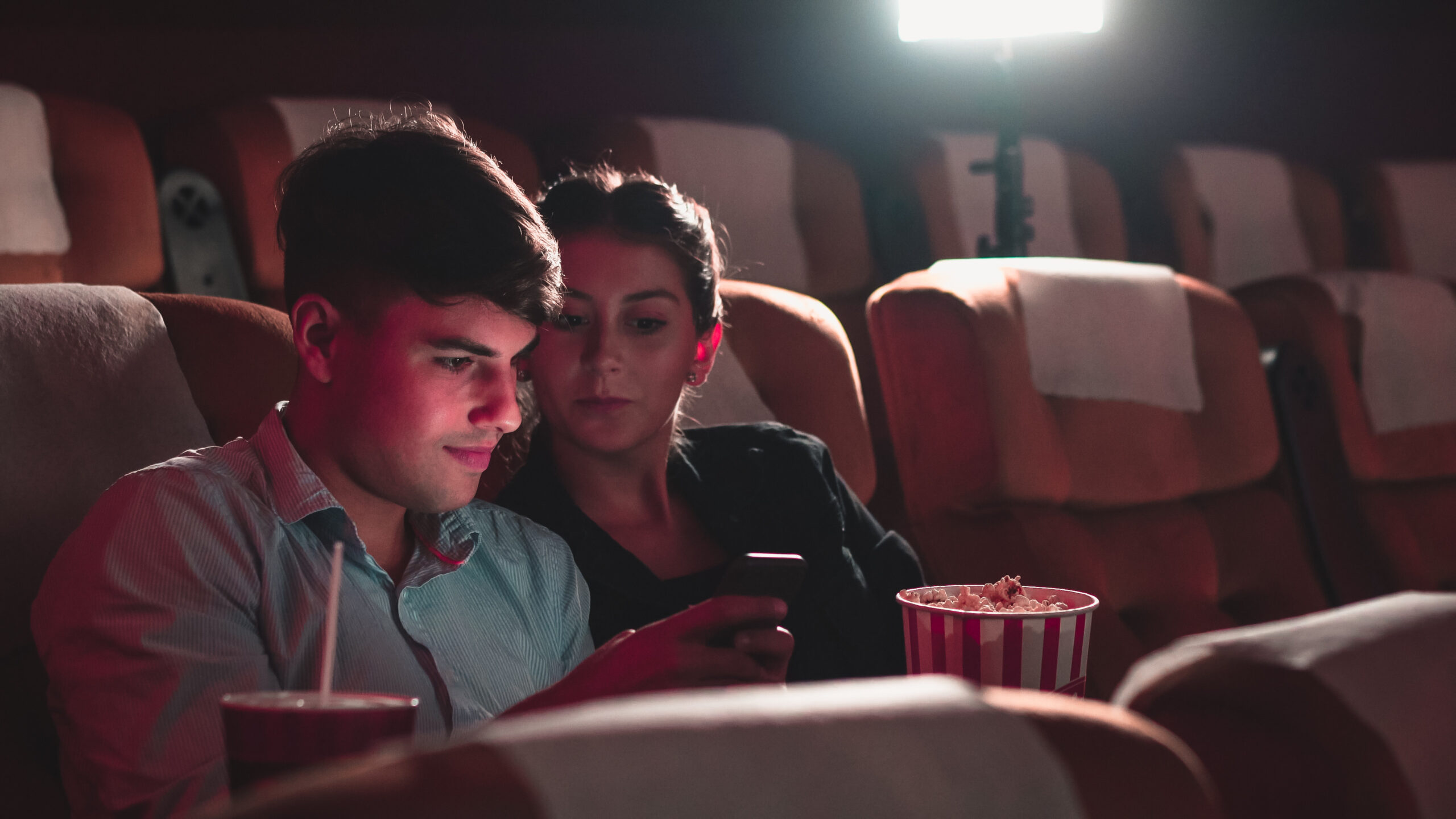 watch movie previews - two people in a movie theater