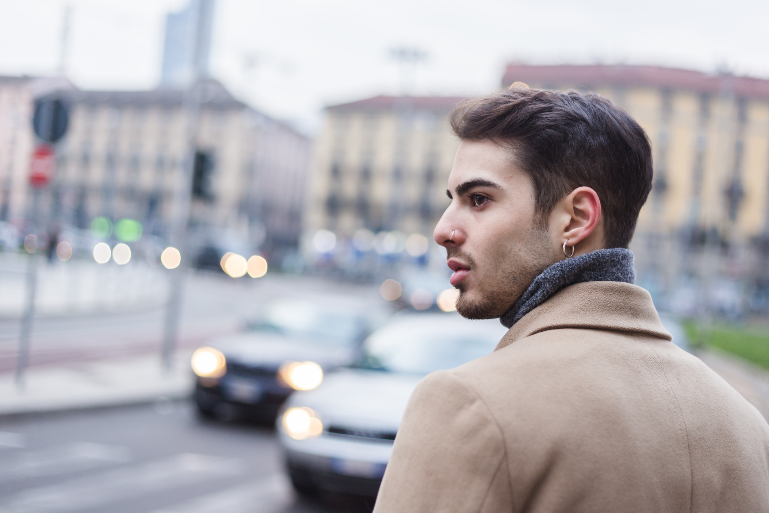 Beautiful young man with short hair posing in an urban context