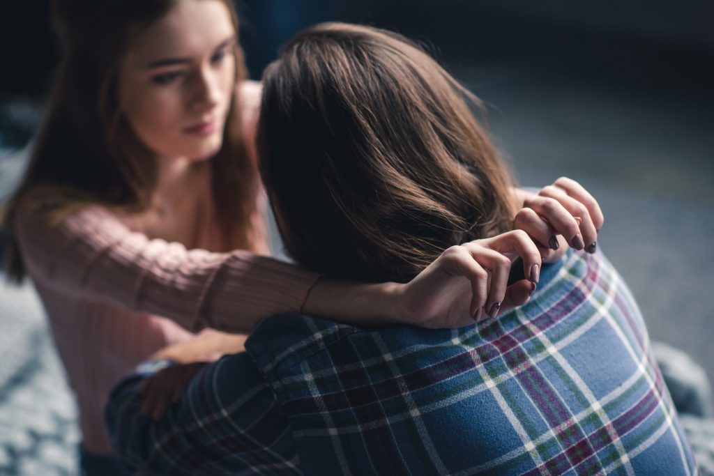 Attractive young couple sitting and hugging at home