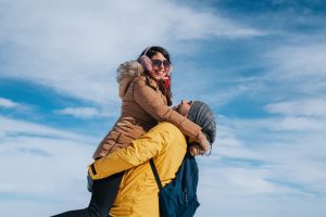 happy couple hugging and laughing outdoors in winter